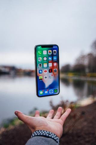 iPhone floating above a hand