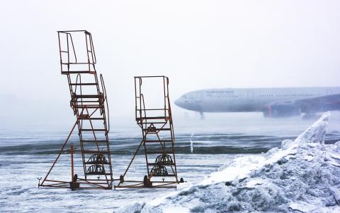 Airplane scaffolds at different heights with an a passenger plane in the winter background