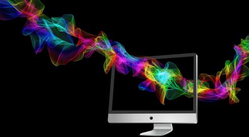 Multi-colored particle waves flowing through computer screen