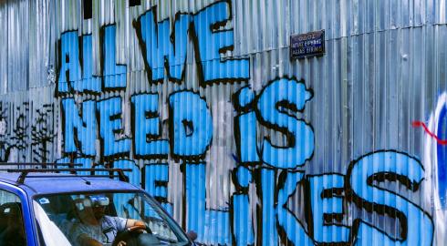 All We Need is More Likes graphitti on a metal wall